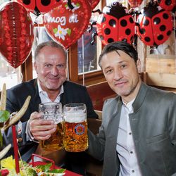 Karl-Heinz Rummenigge and Niko Kovac clink Maßkrüge at Oktoberfest as a giant gingerbread heart reads “I mog di” behind them, October 7, 2018.