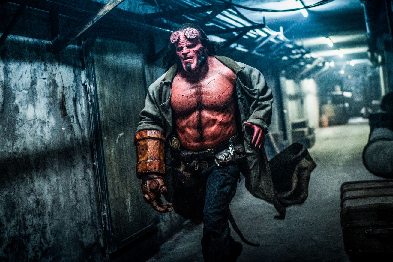 Hellboy runs down a corridor.
