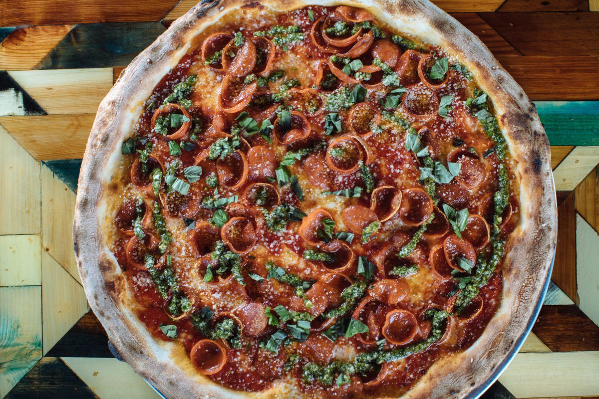 A pepperoni pizza with jalapeno pesto and basil