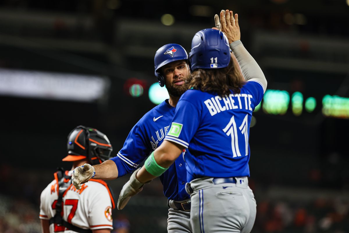 Brandon Belt of the Toronto Blue Jays celebrates with Bo Bichette after hitting a two-run home run against the Baltimore Orioles during the tenth inning at Oriole Park at Camden Yards on August 22, 2023 in Baltimore, Maryland.