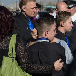 Alex Brotherson, brother of West Valley police officer Cody Brotherson, is hugged by family members following Cody's funeral at the Maverik Center in West Valley City on Monday, Nov. 14, 2016.