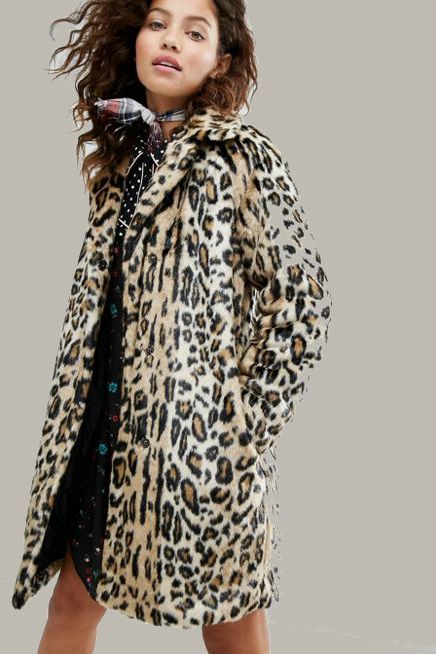 A curly-haired model in a leopard coat