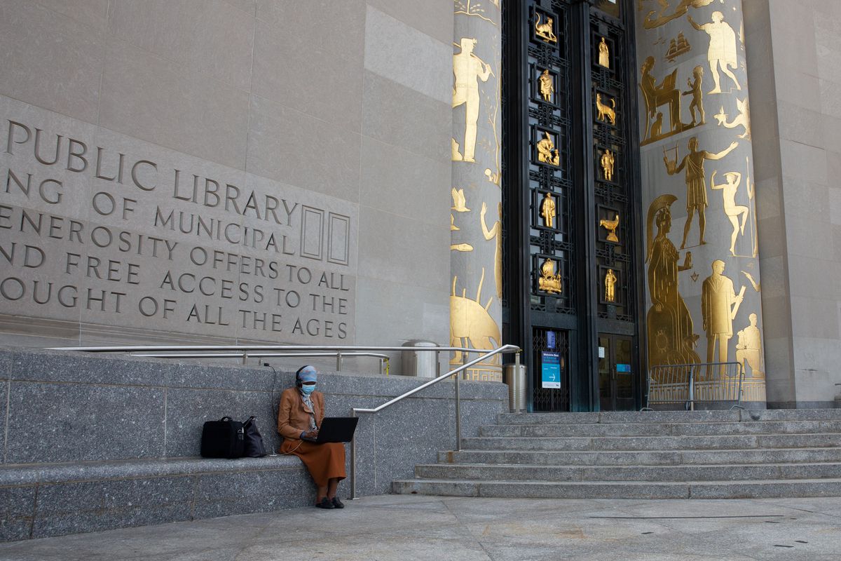 A woman uses free wifi from the Brooklyn Central Public Library, Sept. 14, 2020.