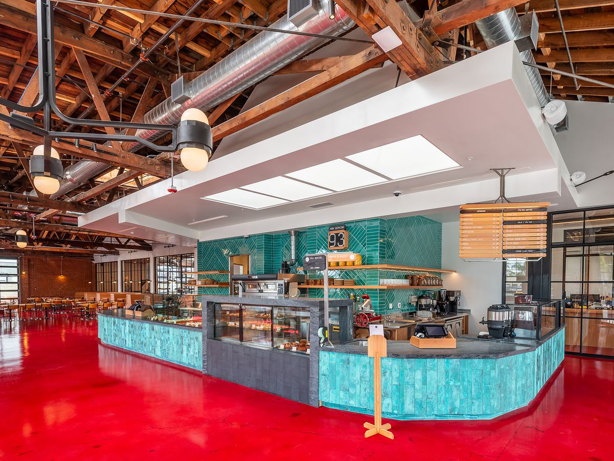 A teal counter and red floor of a new coffee shop.