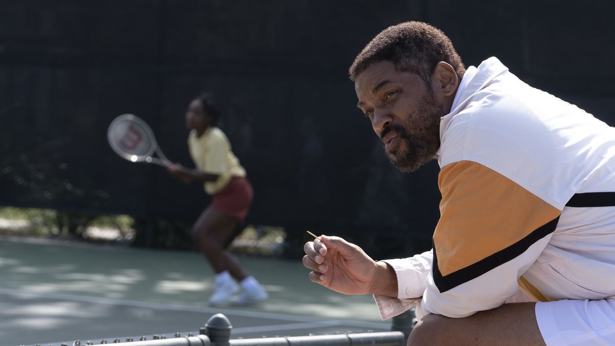 Will Smith as Richard Williams sits by a tennis court watching his daughter play