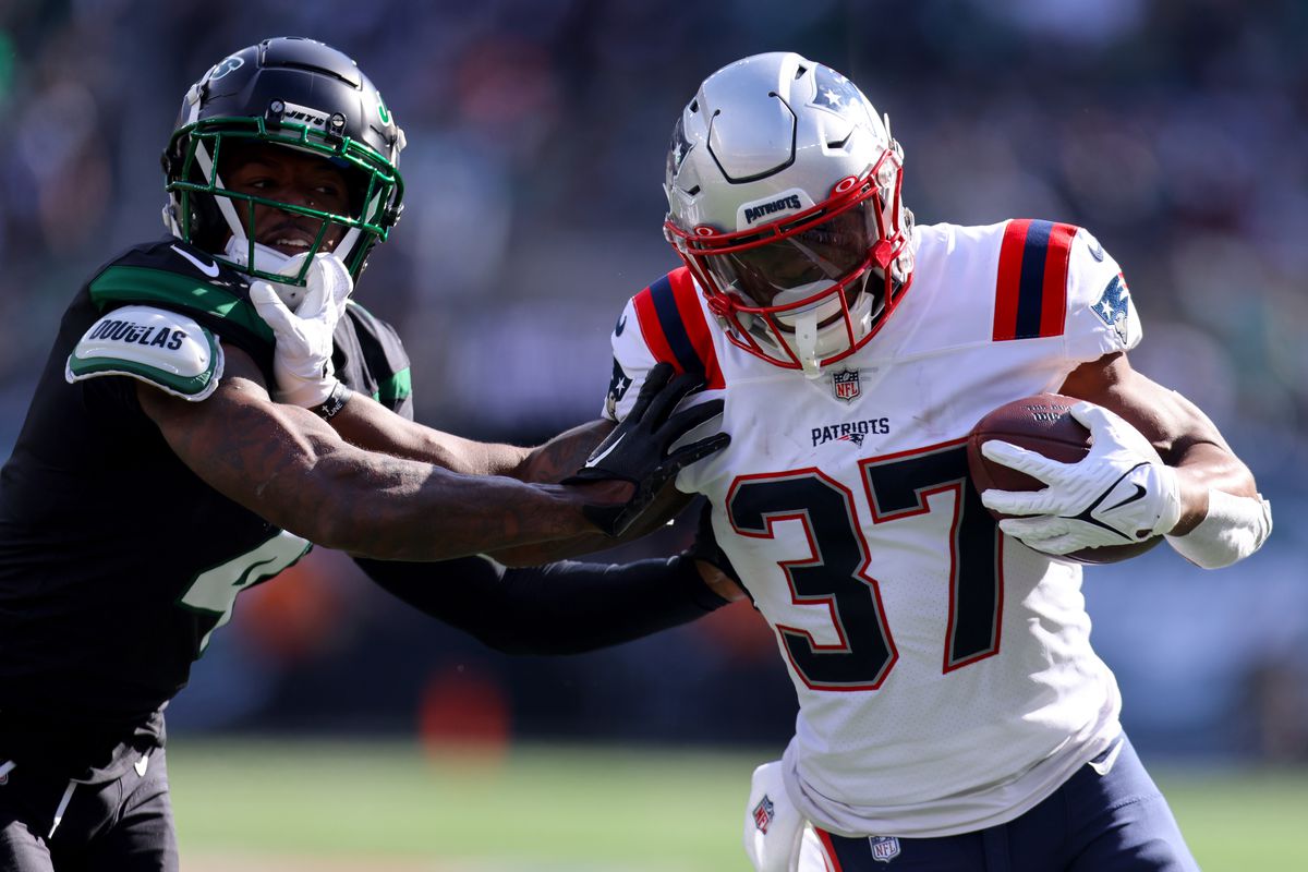 Damien Harris #37 of the New England Patriots runs with the ball as D.J. Reed #4 of the New York Jets defends during the first half at MetLife Stadium on October 30, 2022 in East Rutherford, New Jersey.