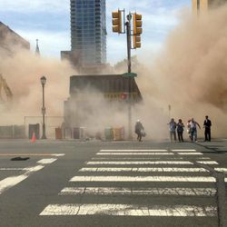 In this photo provided by Jordan McLaughlin, a dust cloud rises as people run from the scene of a building collapse on the edge of downtown Philadelphia on Wednesday, June 5, 2013. A building that was being torn down collapsed with a thunderous boom, raining bricks on a neighboring thrift store, killing a woman and injuring at least 13 other people in an accident that witnesses said was bound to happen. 