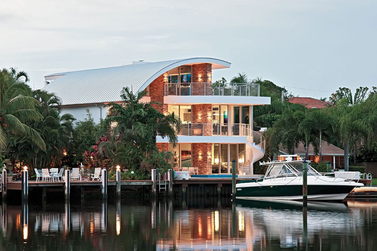 A canalfront home in Fort Lauderdale with three stories and a unique curved roof