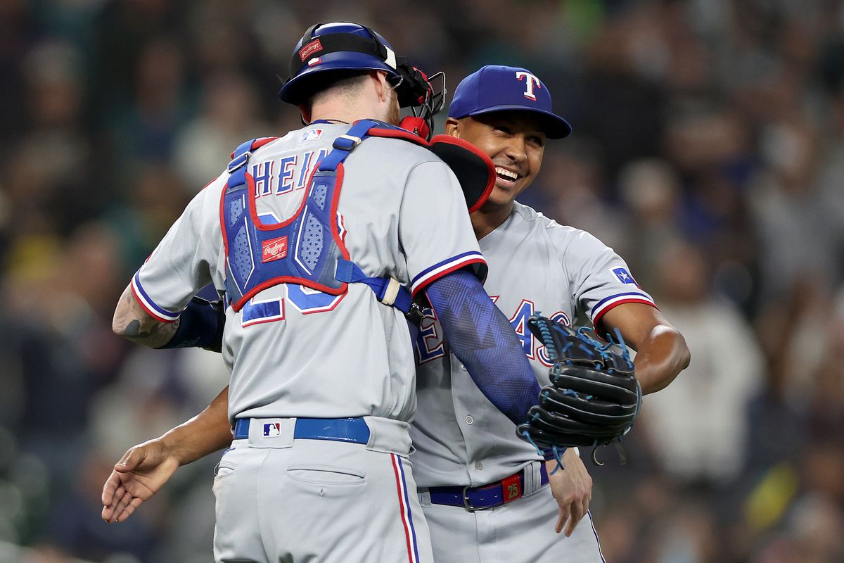 Jonah Heim and Jose Leclerc of the Texas Rangers celebrate after beating the Seattle Mariners 6-1 to clinch a 2023 MLB playoff berth at T-Mobile Park on September 30, 2023 in Seattle, Washington.