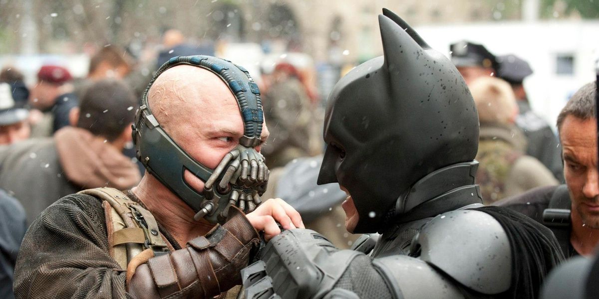 Tom Hardy as Bane and Christian Bale as Batman struggle in The Dark Knight Rises