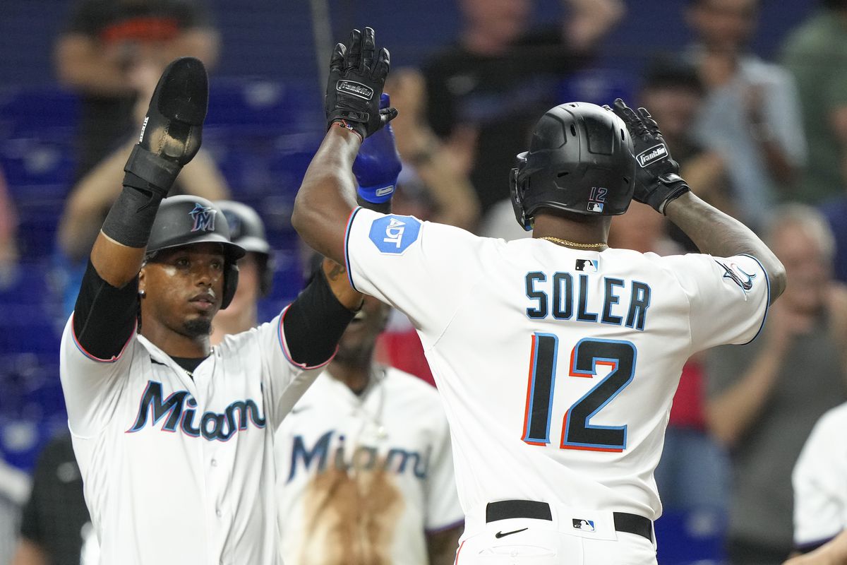 Jorge Soler #12 of the Miami Marlins is congratulated by Jean Segura #9 after hitting a home run in the seventh inning at loanDepot park on April 17, 2023 in Miami, Florida.