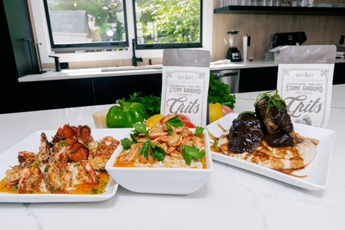 Three large white serving dishes contain grilled lobster tail and grits, shrimp and grits, and oxtail and grits from Bryant “Chef Baul” Williams in Atlanta.