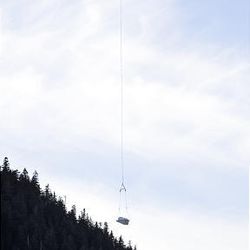A crate with snow carried by a helicopter arrives at the Cypress Mountain snowboard and freestyle ski venue at the Vancouver 2010 Olympics in Vancouver, British Columbia, Tuesday.