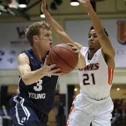 BYU's Tyler Haws, left, looks to pass under pressure from Pepperdine's Shawn Olden during the first half of an NCAA college basketball game Thursday, Feb. 5, 2015, in Malibu, Calif.