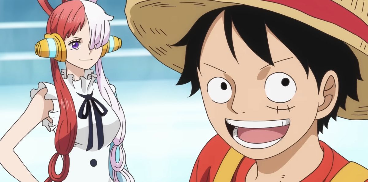 Luffy, um garoto pirata de cabelos escuros usando um chapéu de palha, sorri em primeiro plano como Uta, uma cantora diva com longos cabelos meio rosa e meio ruivo, sorri ao fundo em One Piece Film: Red