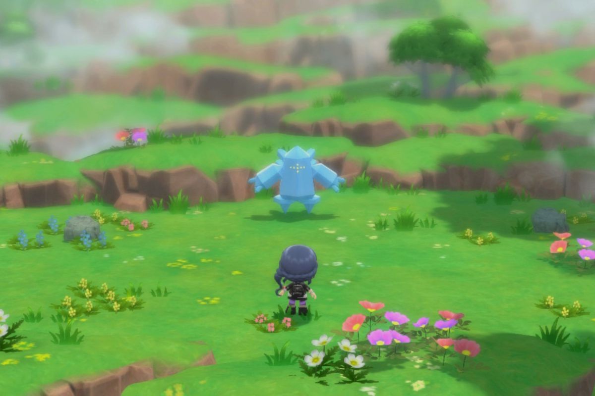Regice sits in a grassy plain in front of the Pokémon trainer