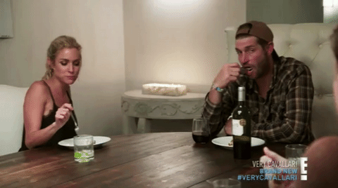 GIF of Kristin Cavallari laughing and Jay Cutler looking bored while chewing