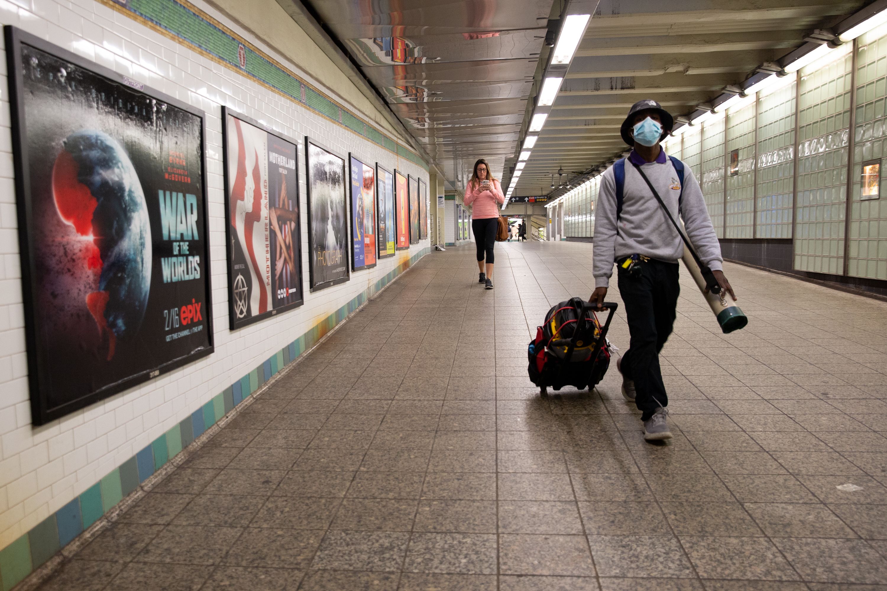 Commuters walk through the Times Square subway station while officials encourage people to work from home during the coronavirus scare.