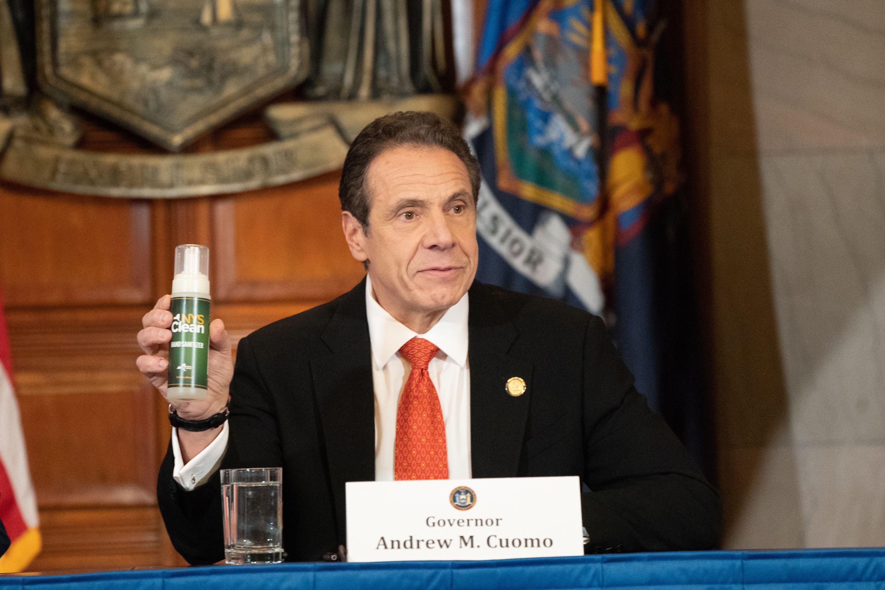 Gov. Andrew Cuomo holds up a bottle of free New York State hand sanitizer.