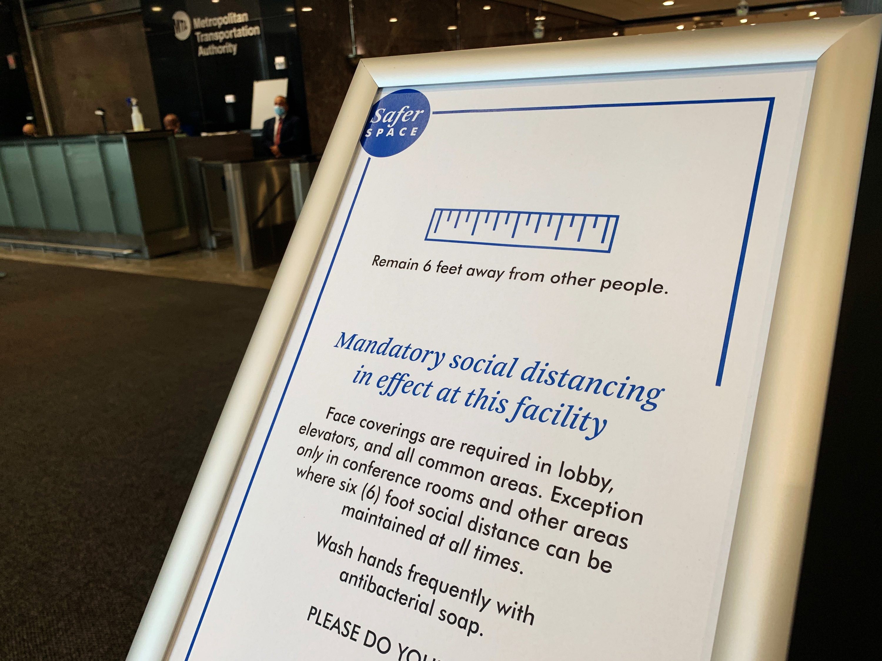 A sign at MTA headquarters gives reminders of social distancing rules, among other requirments.