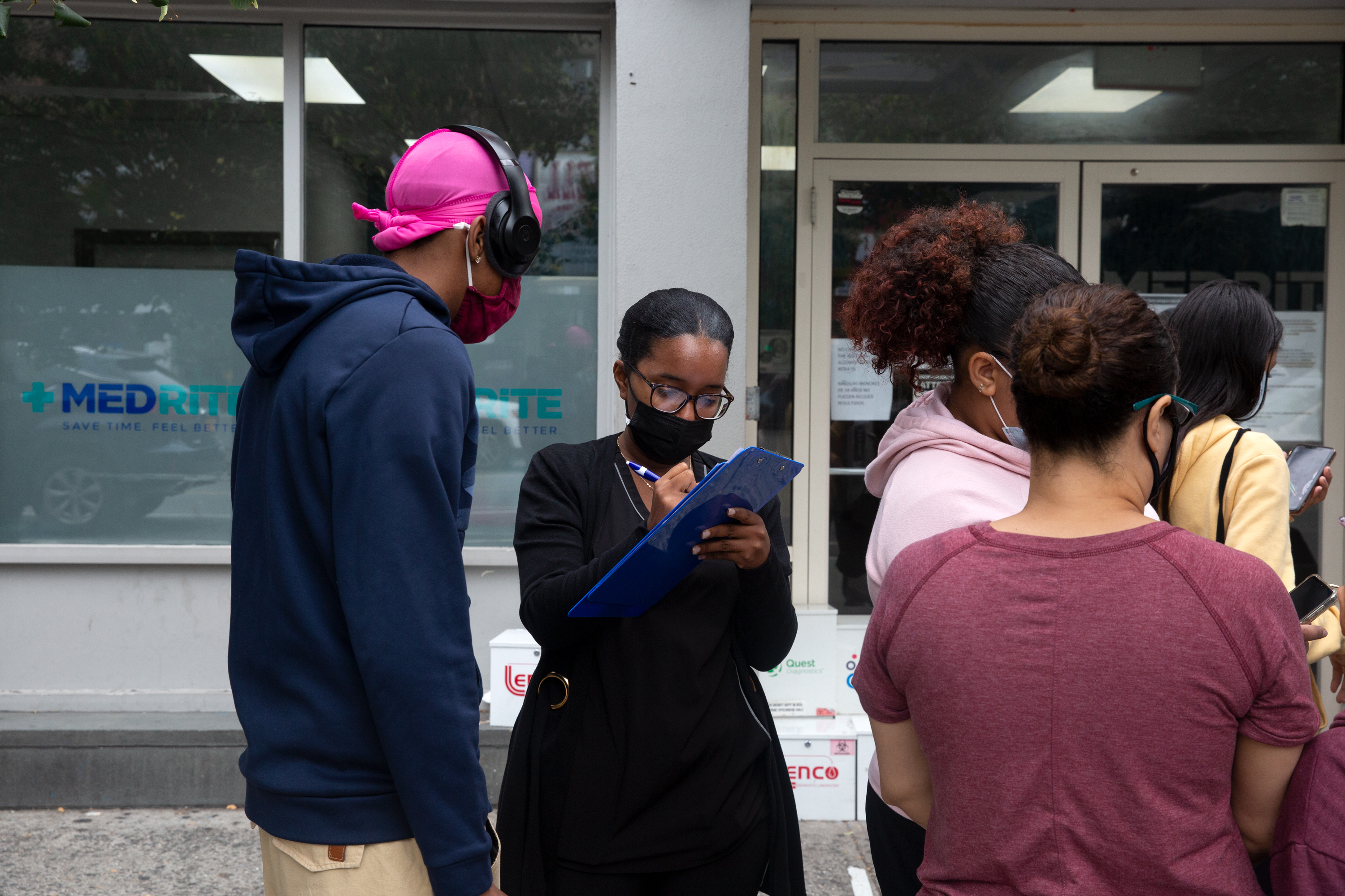 A health care worker signs people in outside an urgent care COVID testing site on Dyckman Street in Inwood, Oct. 6, 2021.