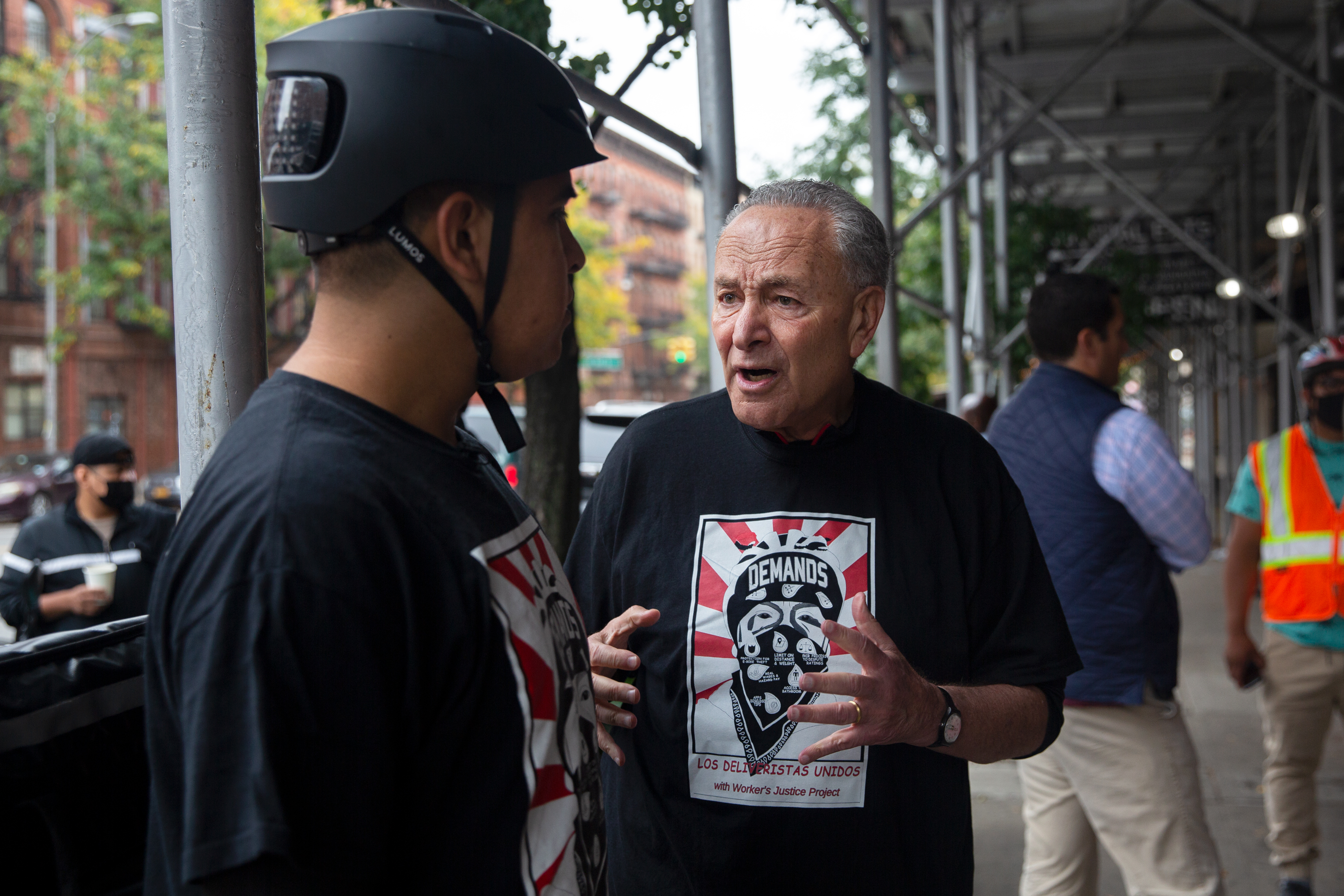 Senate Majority Leader Chuck Schumer speaks with Jonán, a member of Los Deliveristas Unidos, in Harlem.