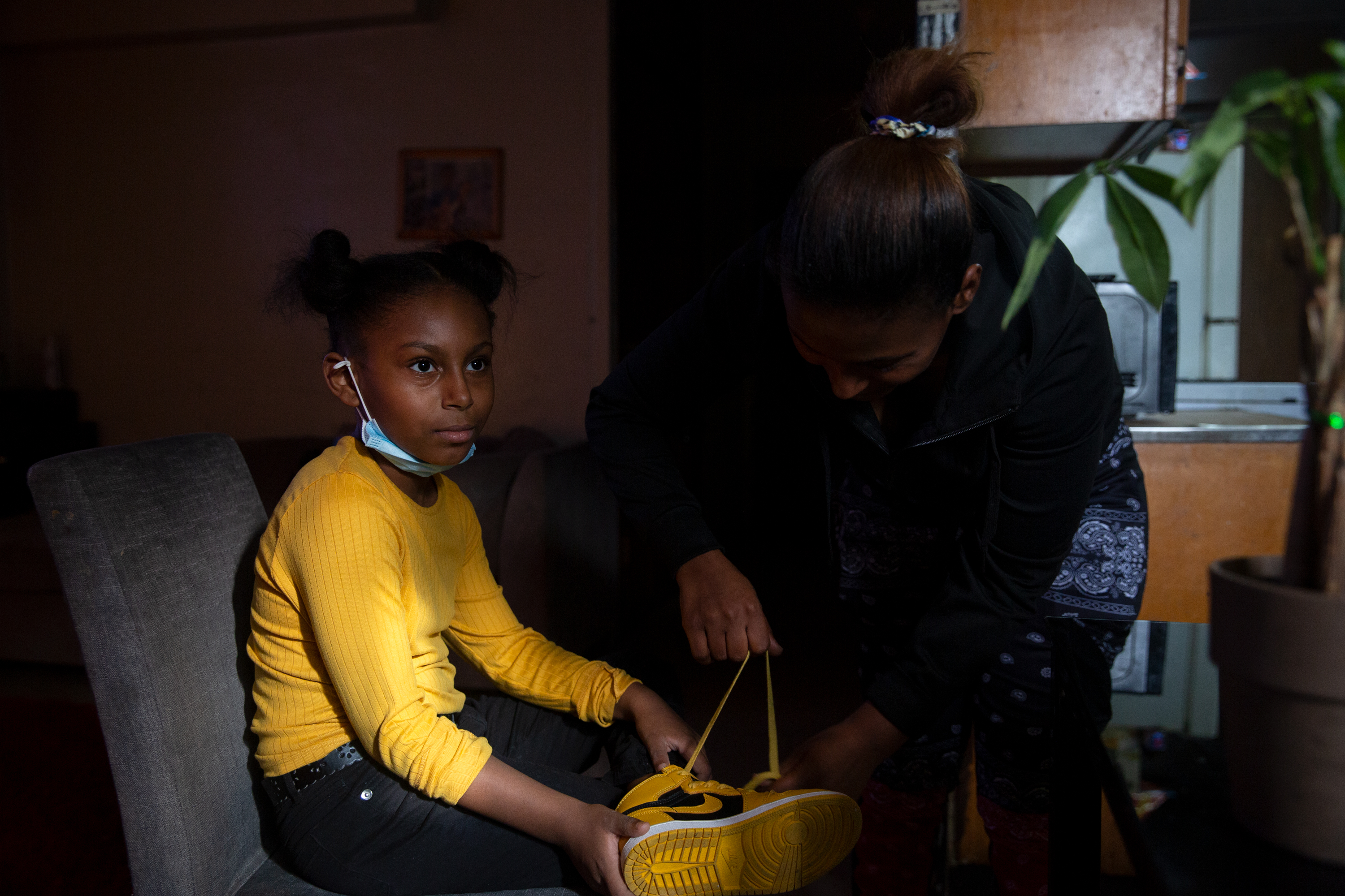 Shari Broomes helps her 8-year-old daughter, Mikhaila Bonaparte.