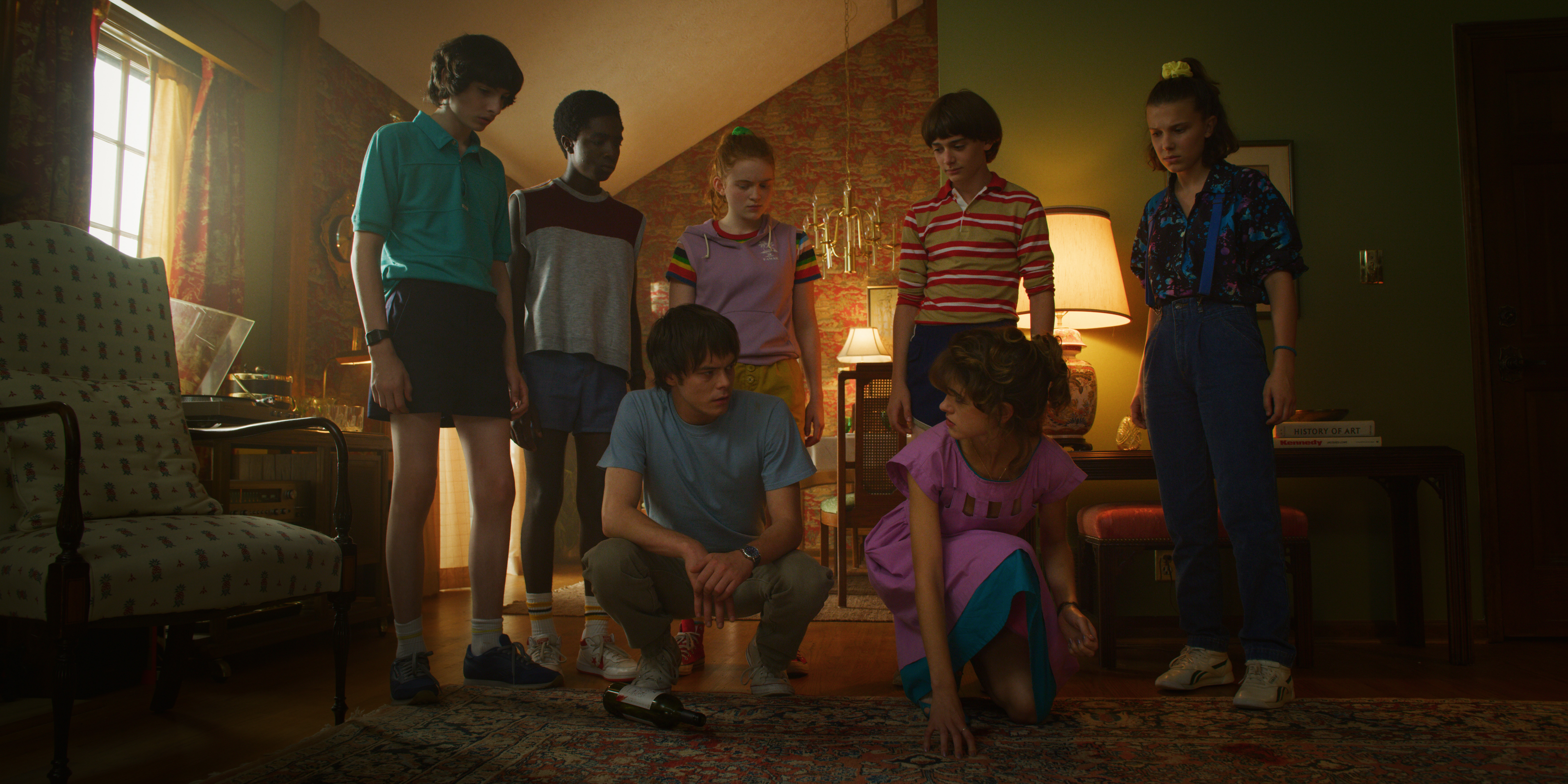 Mike, Lucas, Max, Jonathan, Will, El, and Nancy in a living room in Stranger Things season 3