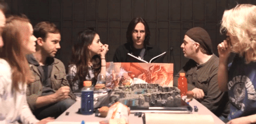 The camera zooms away from Matt Mercer as he announces the Critical Role team wins and everyone cheers