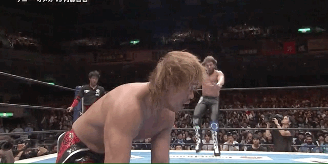 Kenny Omega attacks his opponent with a flying knee strike