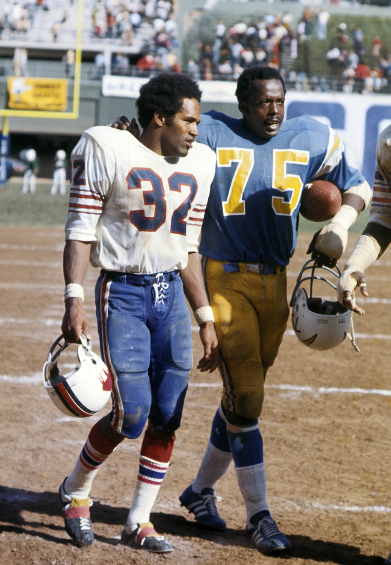 Buffalo Bills running back O.J. Simpson (32) walks off the field with San Diego Chargers defensive tackle Deacon Jones (75) at Jack Murphy Stadium on September 23, 1973