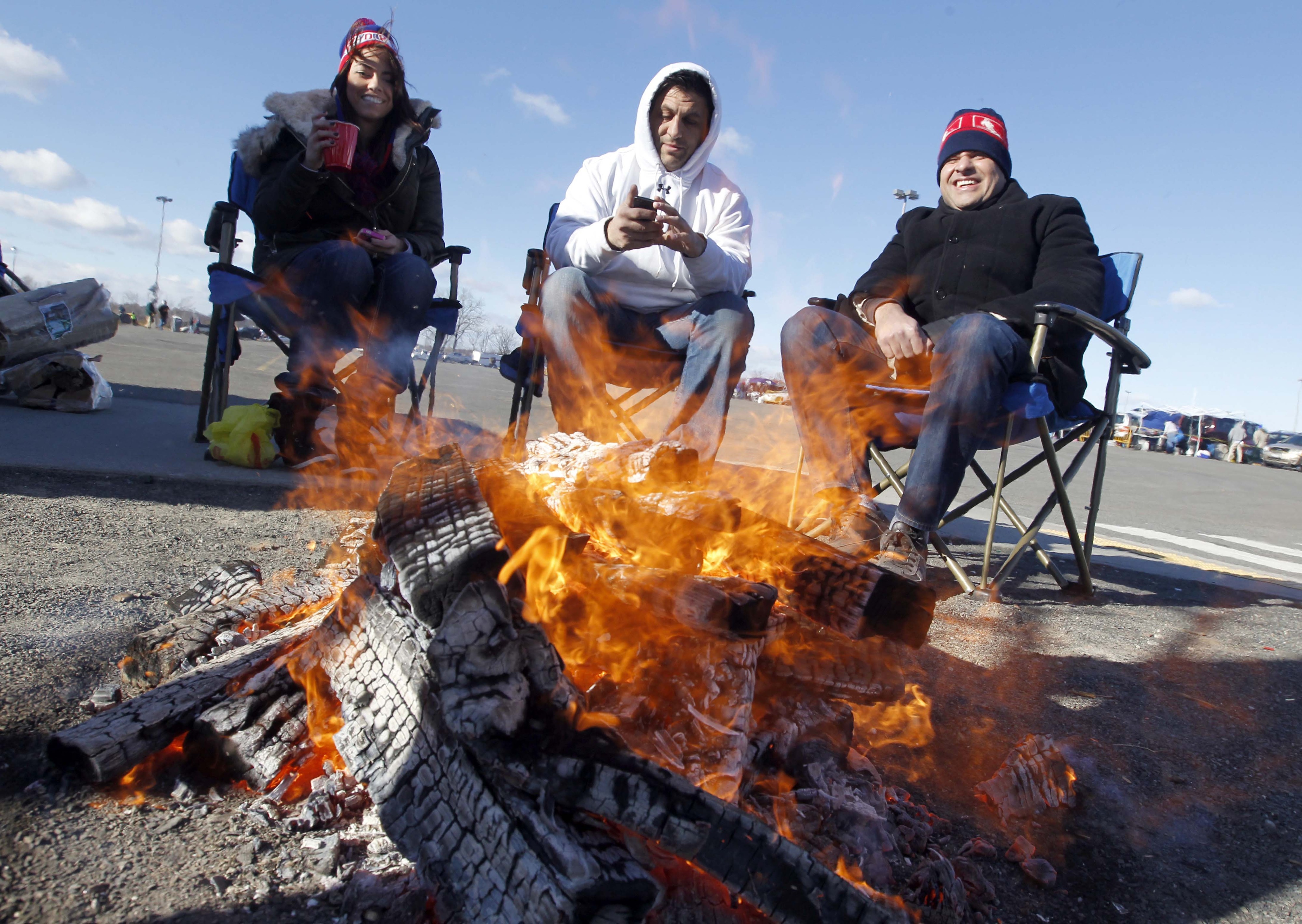Fans warm up with a pre-game fire