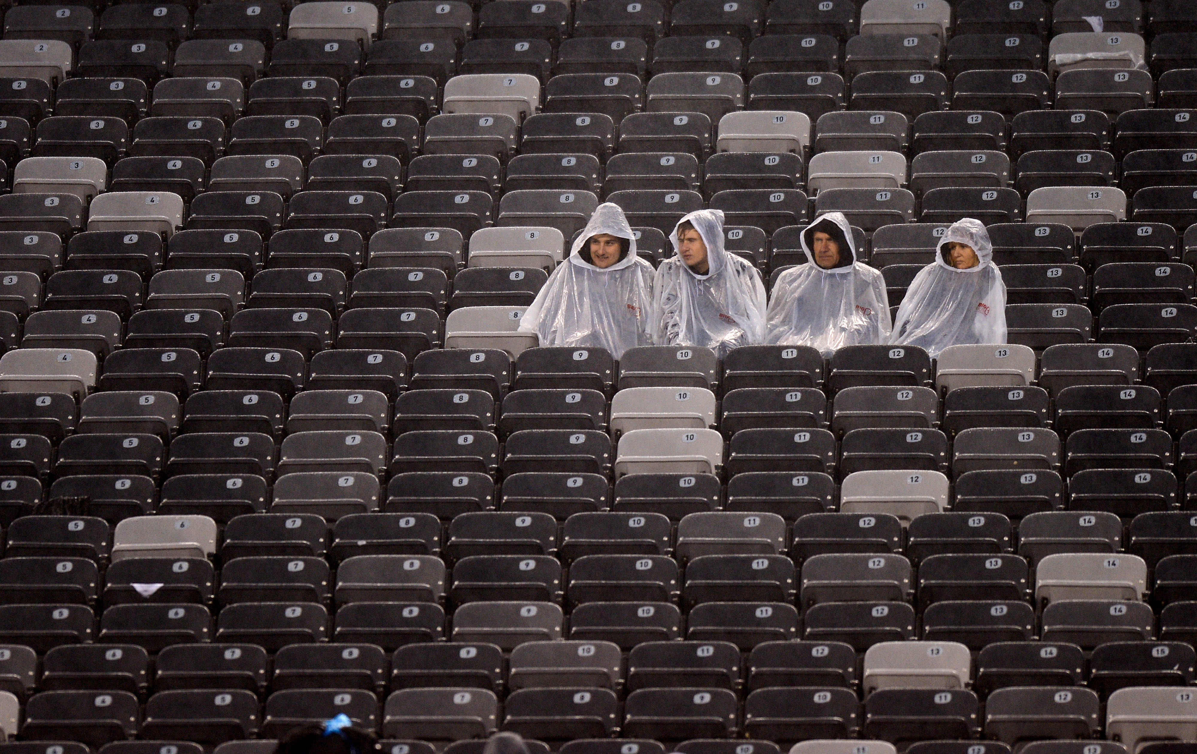 Solitary fans sit in the rain during the second half