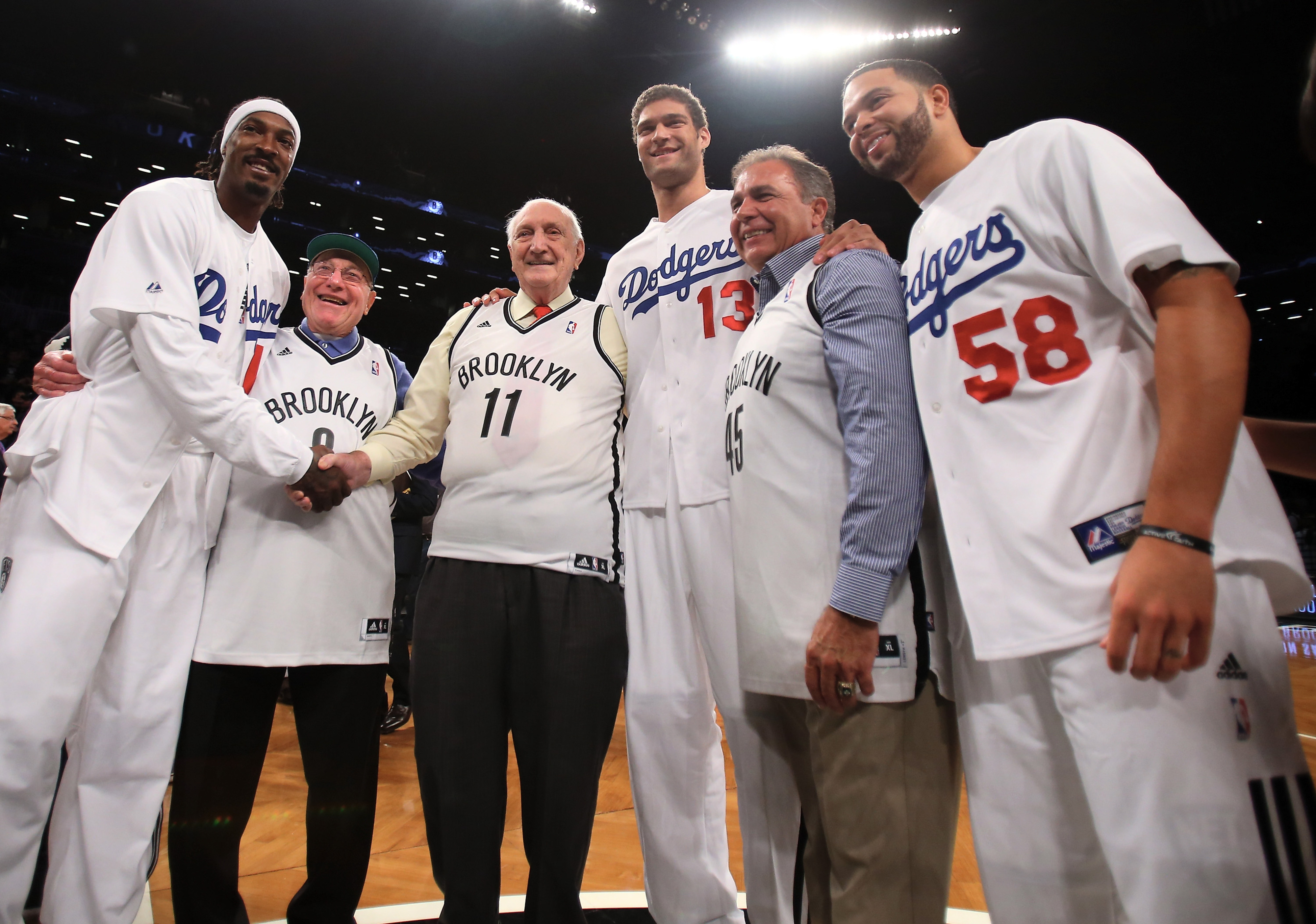 Former Brooklyn Dodgers Ralph Branca, Joe Pignatano and Gil Hodges's son Gil Hodges Jr. exchange jersey with Gerald Wallace (45),Brook Lopez (11) and Deron Williams (8). (Photo by Elsa/Getty Images)