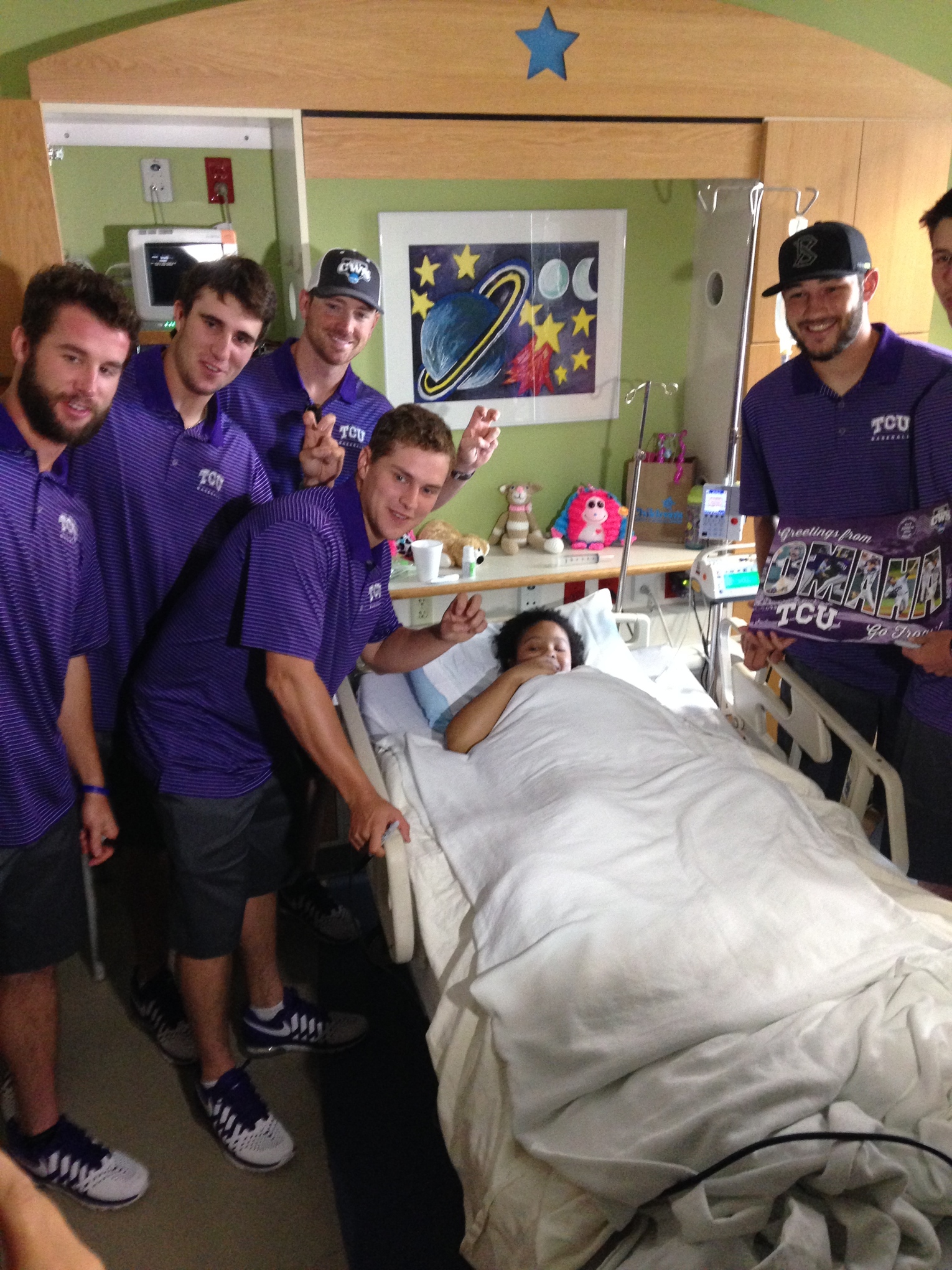 TCU players flash the Horned Frog sign with Markeva, a 14-year-old patient