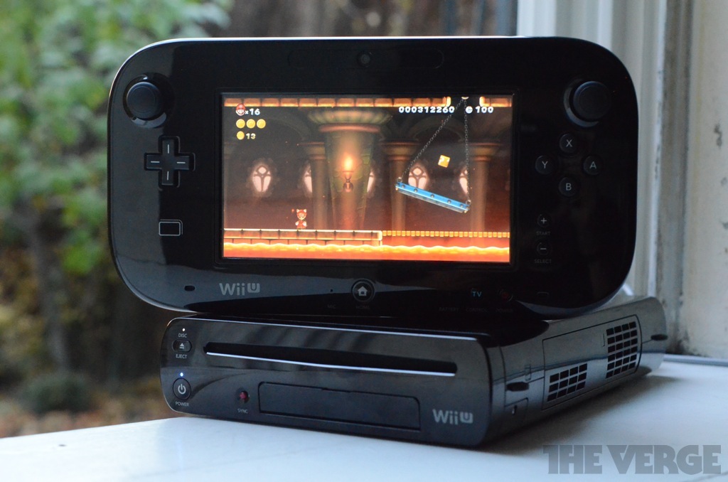 Wii U gamepad screen standing on top of black Wii U console sitting on a window sill and a fiery bowser castle scene on the screen.