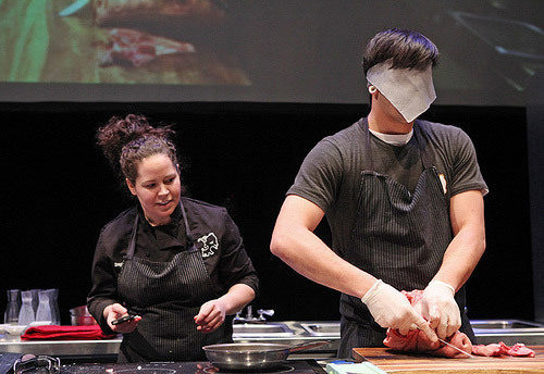 Chef Stephanie Izard watches Girl & The Goat butcher Norbert Moniz blindly deface a pig head.
