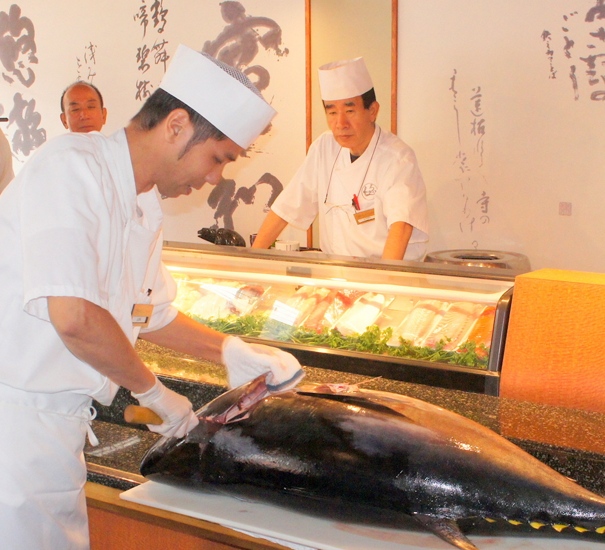 Takai starts cutting tuna. 