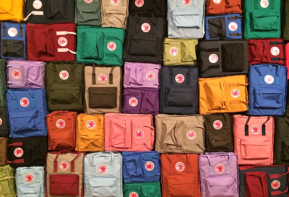 A wall of various sized Kånken backpacks