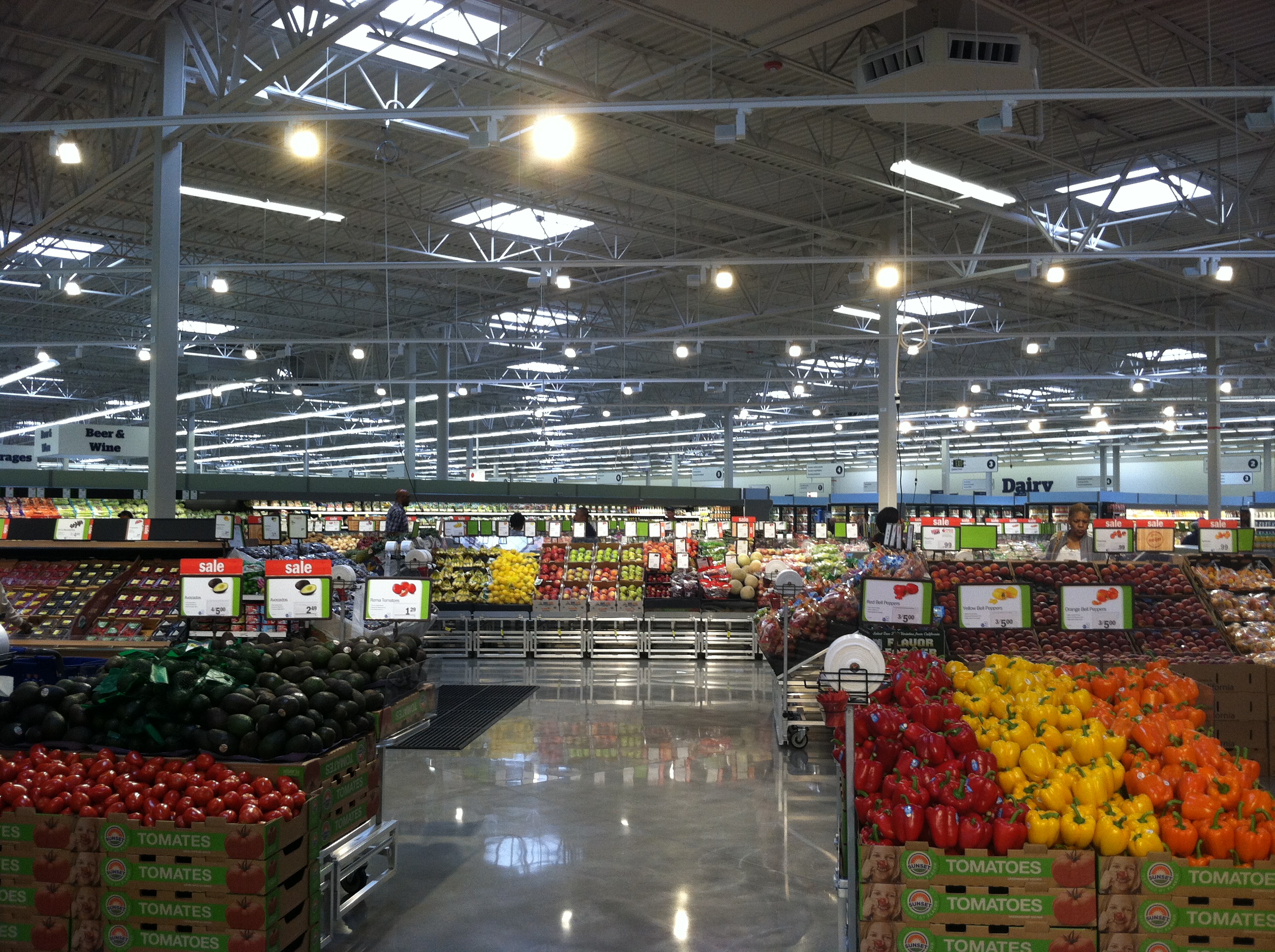 A grocery aisle filled with fruits and vegetables.