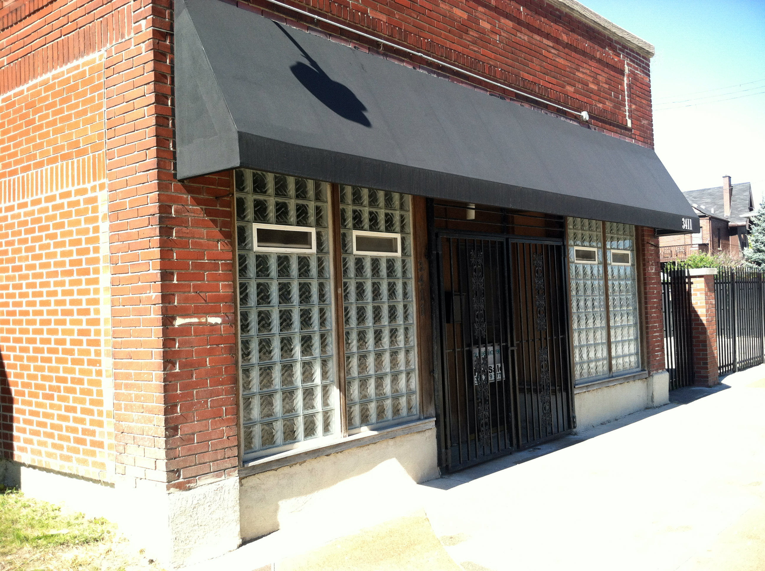 The Le Petit Dejeneur building is gated and displays a "For Sale" sign.