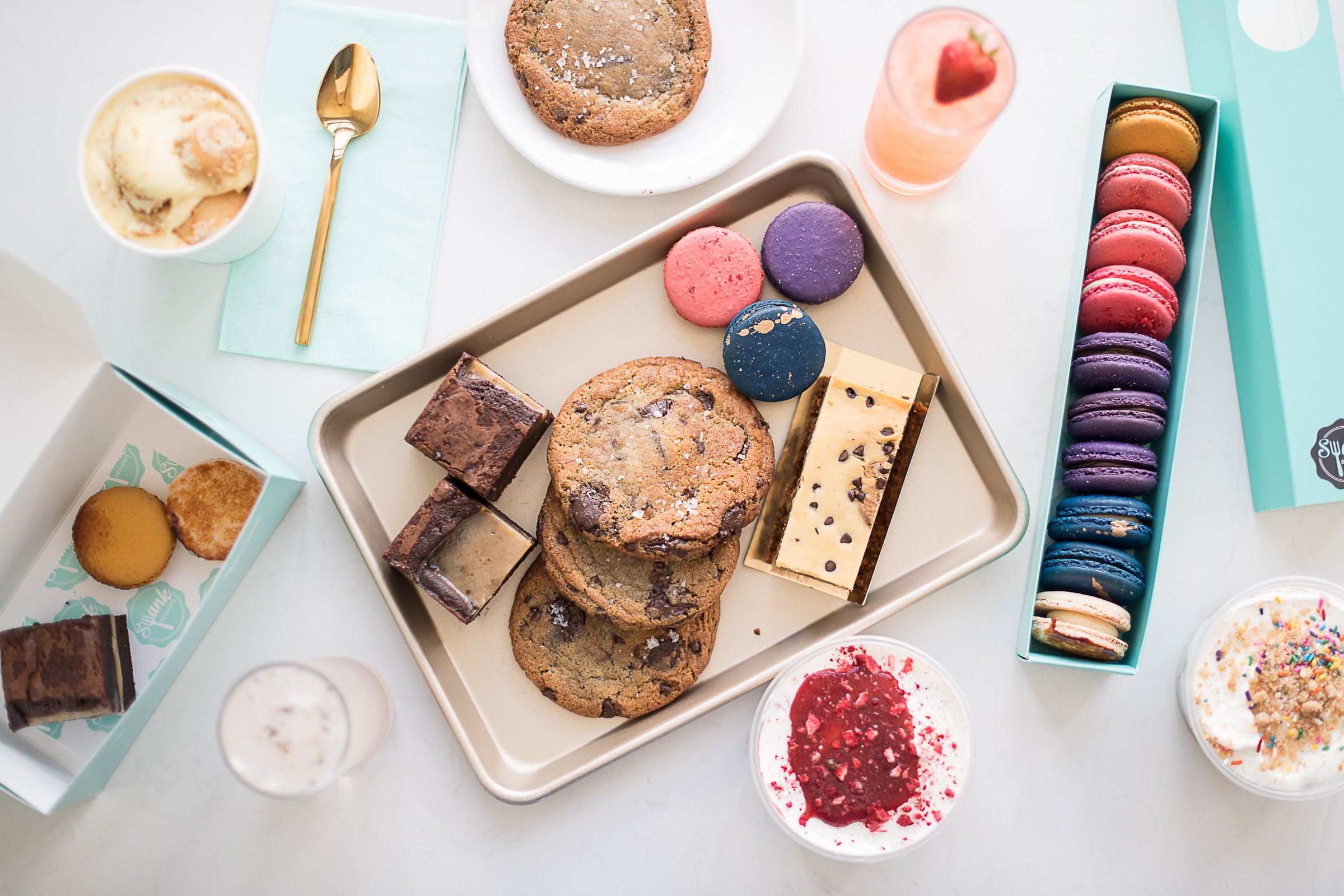 Cookies, macarons, and dessert bars on a tray. 