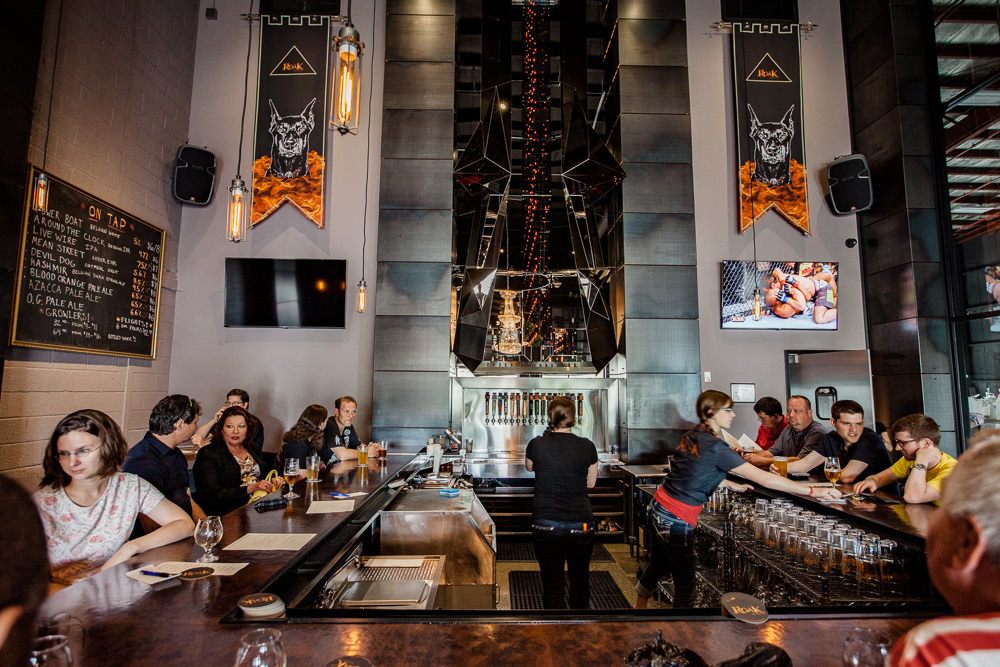 The interior of the Roak Brewing Company taproom is filled with people at a U-shaped bar.