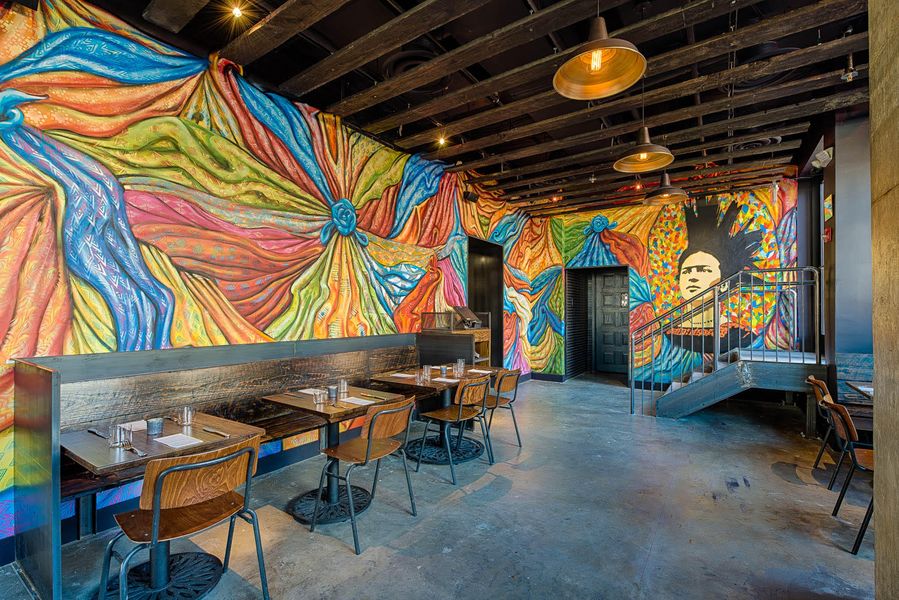 Brightly colored murals in a dining room at Espita Mezcaleria