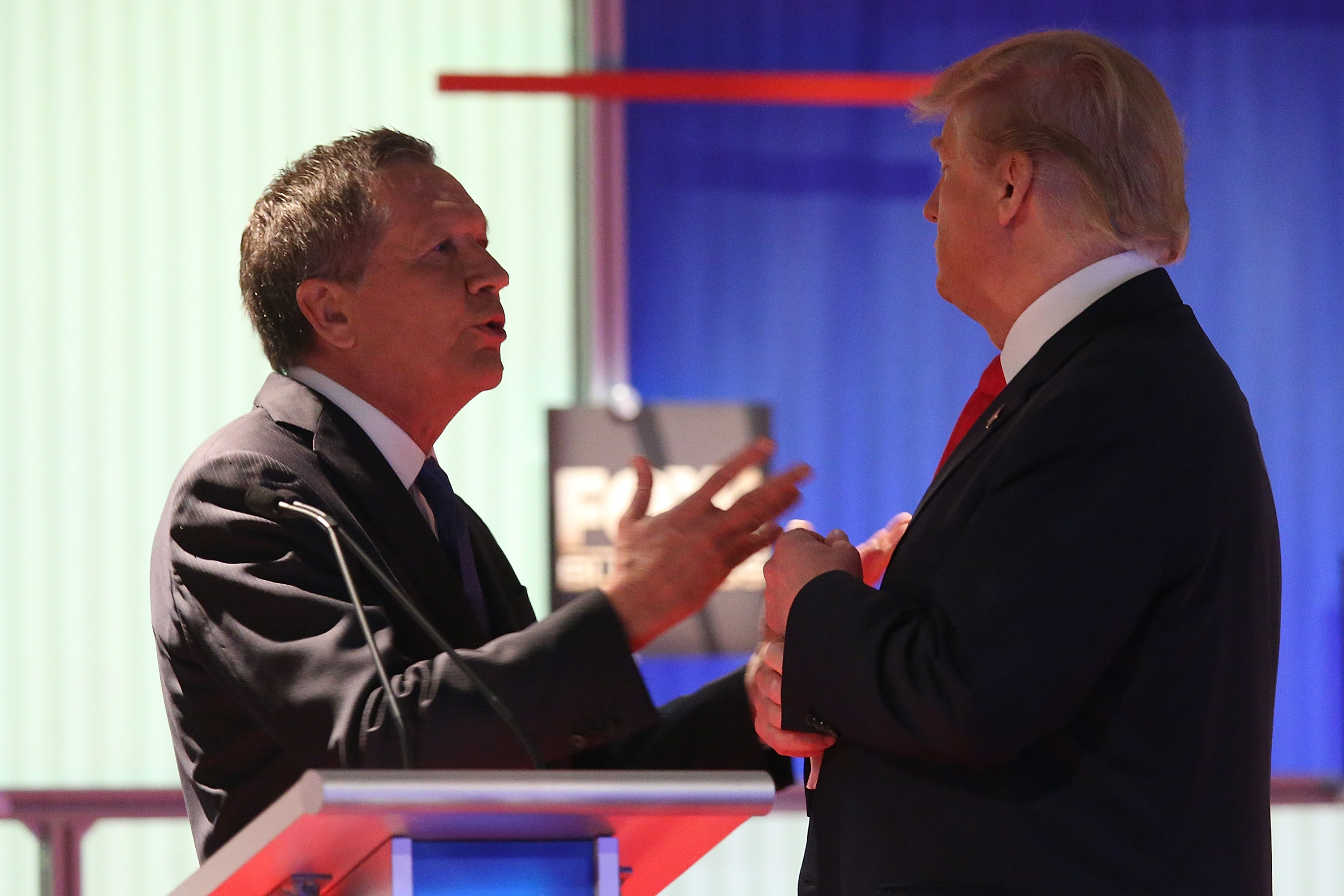 Ohio Gov. John Kasich and Donald Trump talk during a commercial break during the Fox Business Network Republican presidential debate at the North Charleston Coliseum and Performing Arts Center on January 14, 2016, in North Charleston, South Carolina.