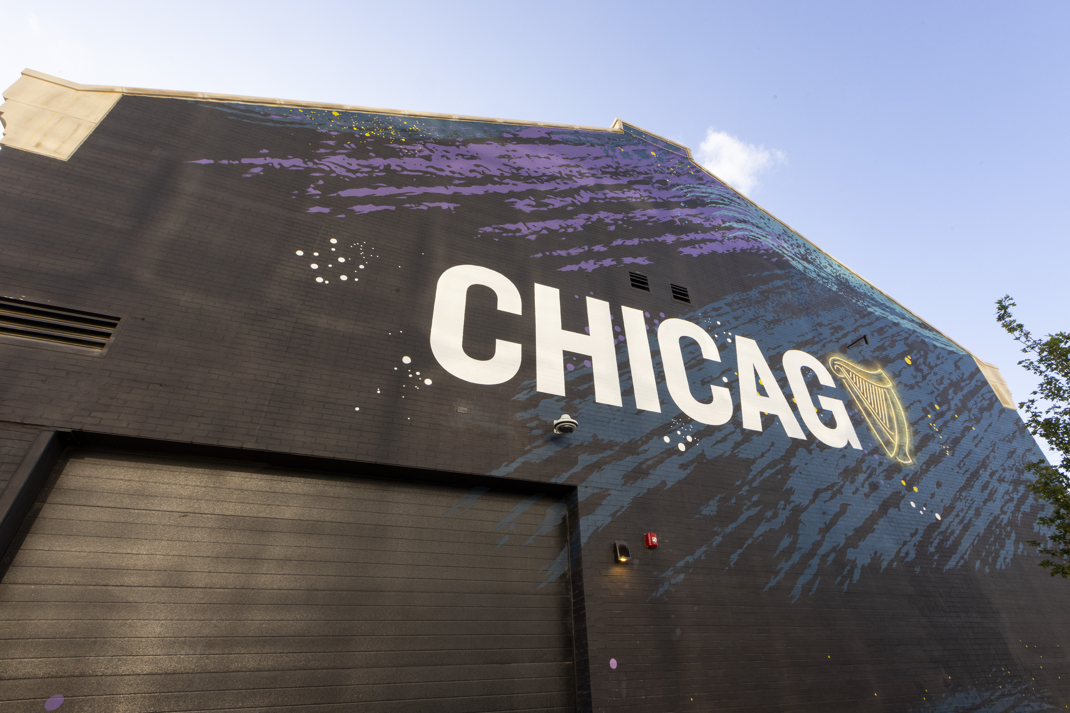 A large building with the letters “CHICAGO” stenciled in white. The “O” is replaced with a harp.