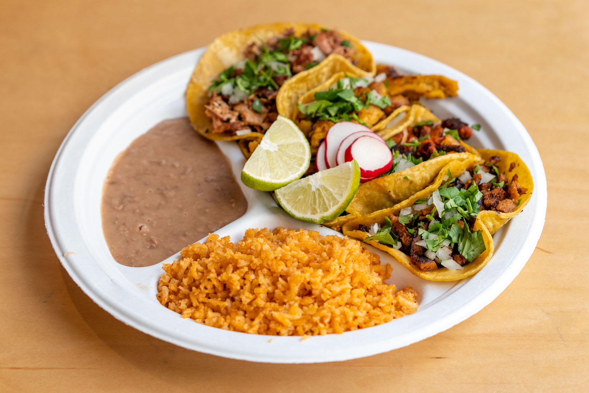 A place of three tacos, rice, and beans.
