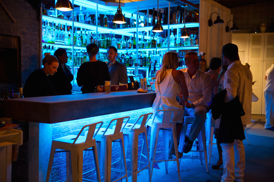 A dim restaurant bar area with blue underlighting.