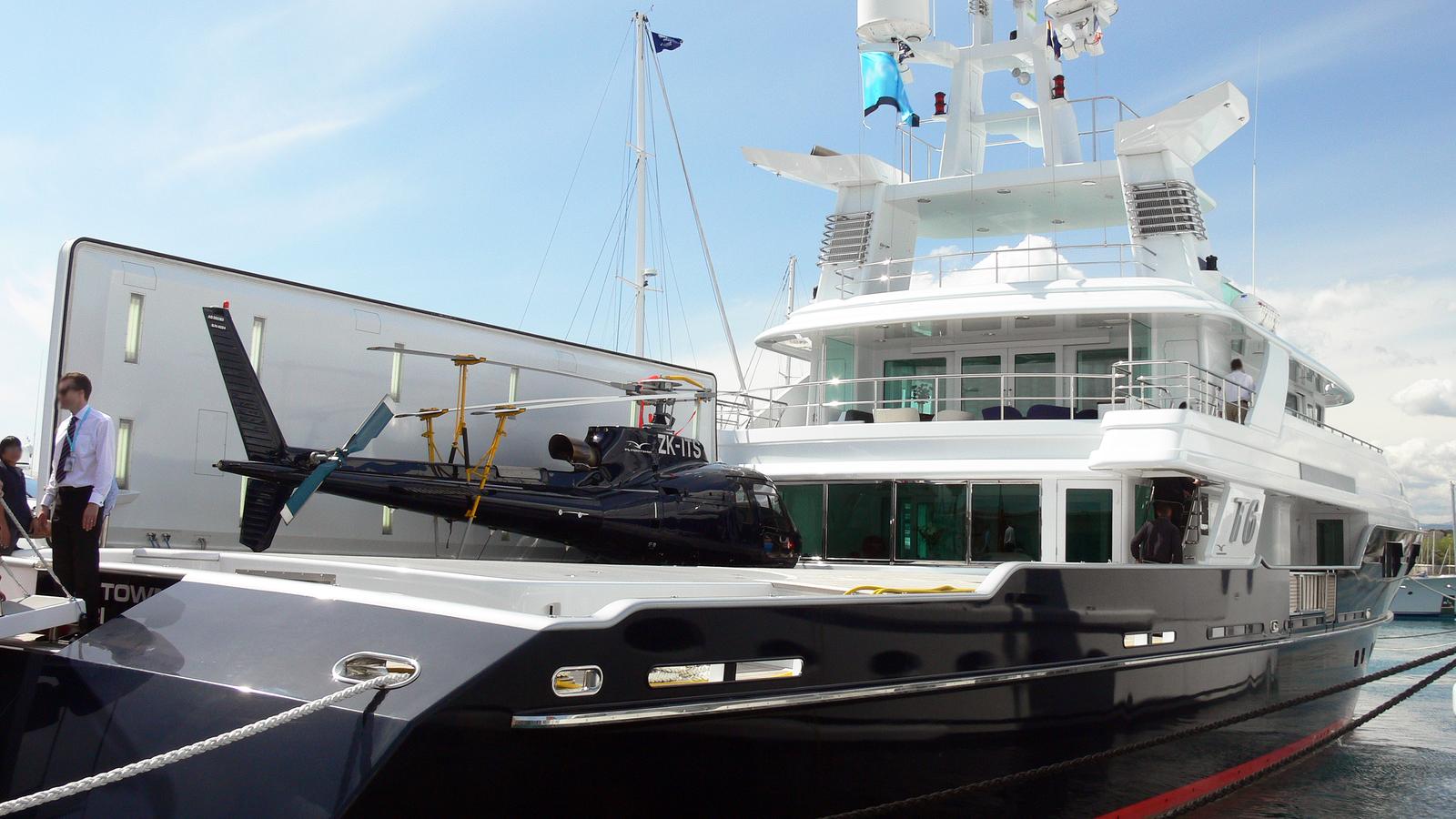A luxury superyacht with a helicopter on the stern