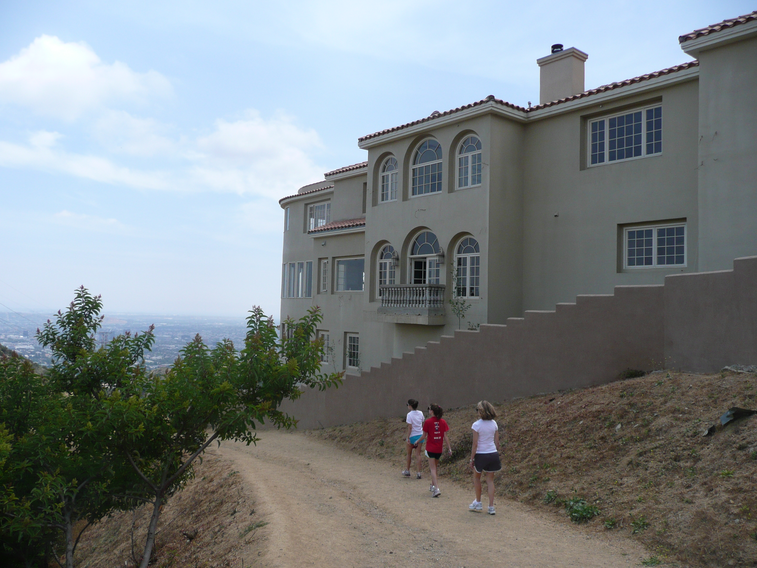 Hikers walk next to huge pink house
